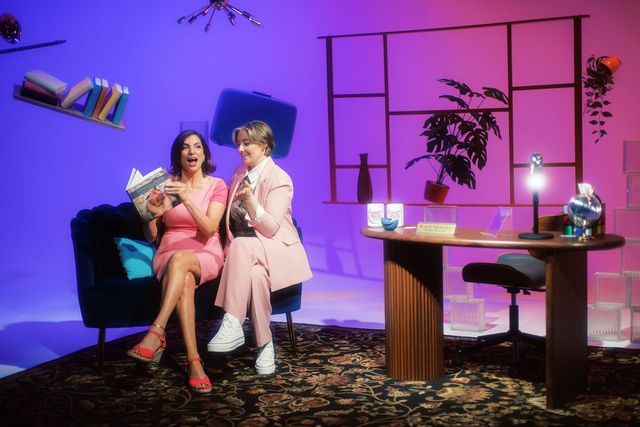 Katie and her guest laughing on the couch