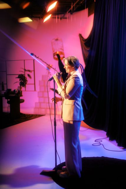 Katie on stage under a warm spotlight